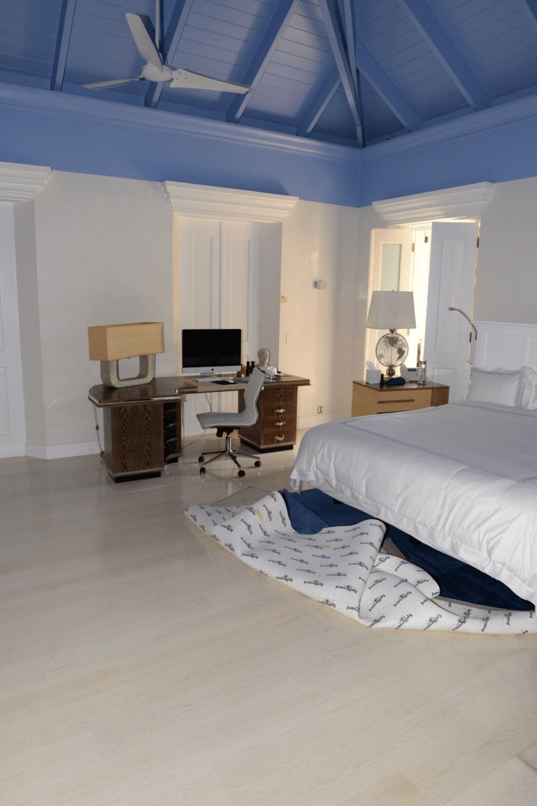 A made-up twin bed with fresh bedding in a small room